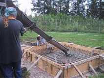Pouring concrete to form the antenna base. Note the wooden shuttering and reinforcing iron grid.  The three foot fittings for the dish legs are already accurately positioned.