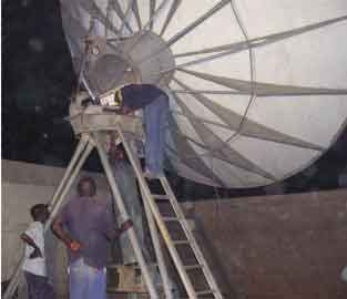 Working at night during rain repointing a customer's large 6.8m satellite dish in Nigeria
