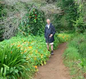 Dressed for walking in cooler weather alongside wild Nasturtiums flowers