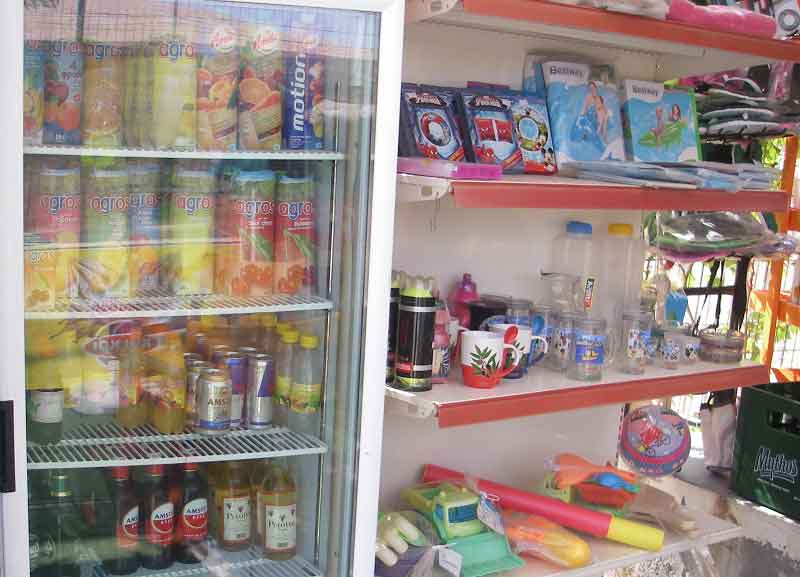 Refrigerated cupboards with cooled drinks and shelving with items on sale