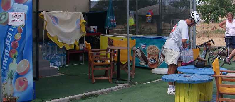 In front of the mini-market, cat on seat, customer loading water